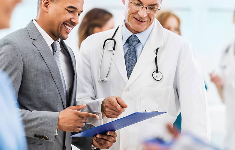 doctor and administration reviewing clipboard